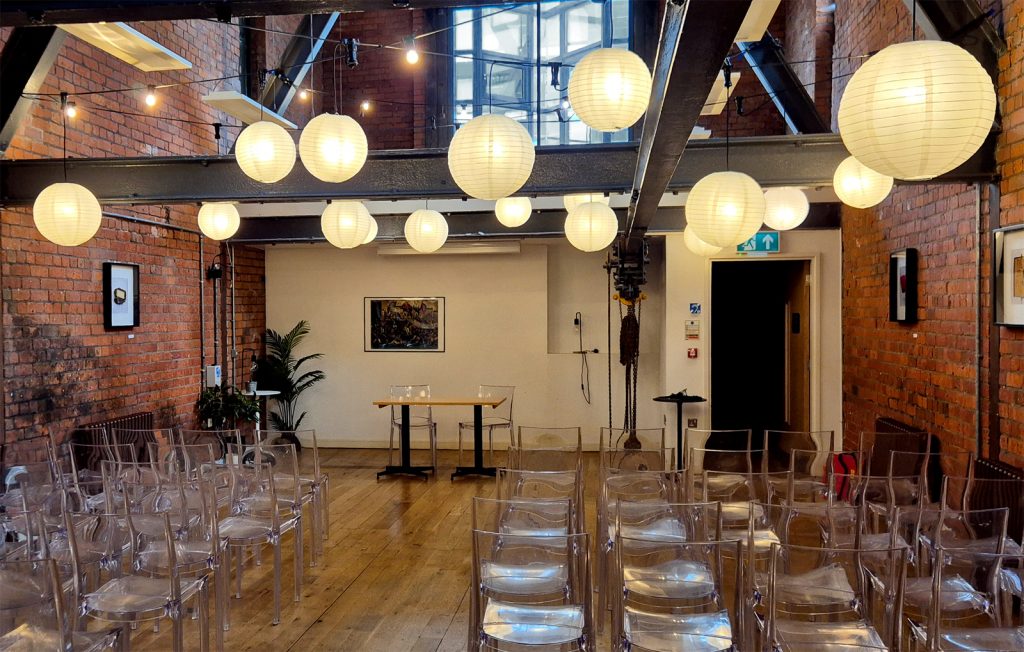 Illuminated Chinese Lanterns and festoon lighting in wedding venue.