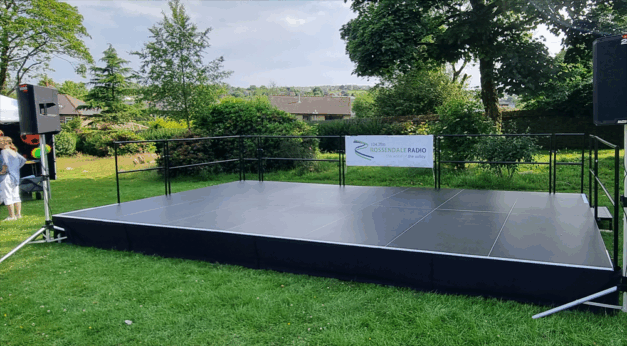 An outdoor stage for a carnival with handrails & steps.